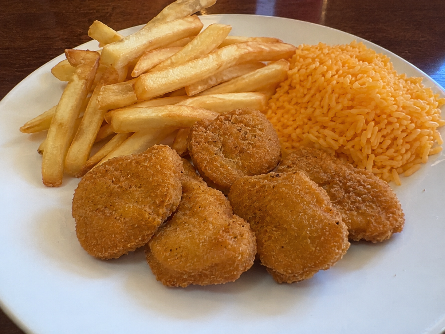 Chicken Nuggets plate served with rice and french fries.